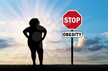 Fat woman and a sign of stop obesity. Concept of obesity