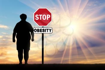 Fat man and a sign of stop obesity. Concept of obesity