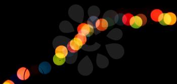 Bright colorful bokeh, row on a black background.