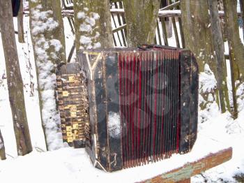 Old harmonica Bologovka on a wooden bench.