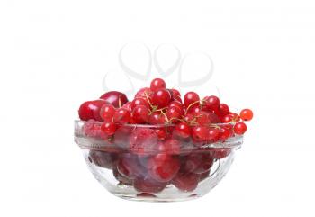 raspberries and currants cherries in a glass on white