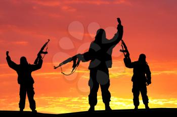Silhouette of military soldier, shot, holding gun, colorful sky, Concept of a terrorist. Silhouette terrorists with rifle, sunset on background 