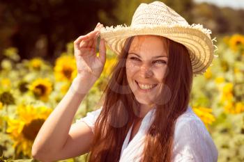 Cute girl in the field full of sunflowers. young beautiful woman on blooming sunflower field in summer