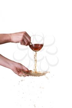 Brown splashes out drink from glass on a white background.