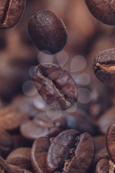 Closeup of coffee beans at roasted coffee. Coffee bean on macro ground coffee background. Arabic roasting coffee - ingredient of hot beverage.