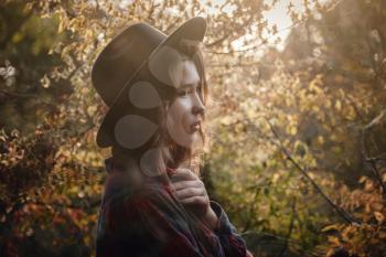 Beautiful Asian woman in a golden autumn forest. Solitude or depression concept. Millenial dealing with problems and emotions.