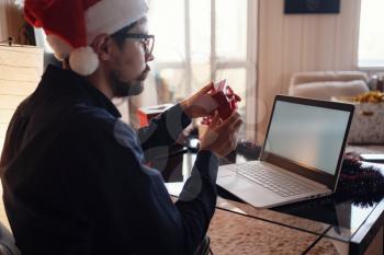 Virtual Christmas day house party. Man smiling wearing Santa hat Business video conferencing Online team meeting video conference calling from home. mock-up