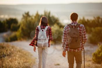 Portrait of happy young couple having fun on their hiking trip. Caucasian and asian hiker couple enjoying themselves on summer vacation. Young people hiking in nature.