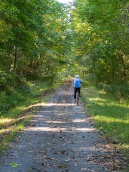 Senior adult caucasian woman on forest trail converted from old railway line as Mon River Trail near Morgantown WV