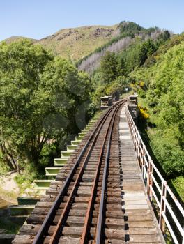 Railway track of Taieri Gorge tourist railway crosses a bridge across a ravine on its journey up the valley