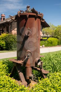Rusty iron wine grape press in garden in Yountville, Napa Valley in California