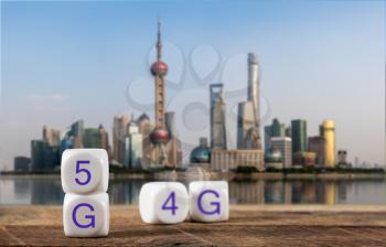 5G spelled in cubes with 4G or LTE blurred behind with city of Shanghai in background