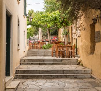 Empty Taverna on steps in ancient neighborhood of Plaka in Athens by the Acropolis
