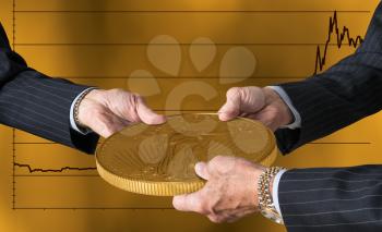 Hands of three financial traders gripping gold eagle coin against a background of rising prices for the currency