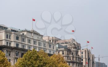 Historic buildings all flying the chinese flag on the Bund in Shanghai, China