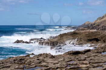 Large waves crash on the shoreline of Ka'ena Point on the extreme west coast of Oahu in Hawaii
