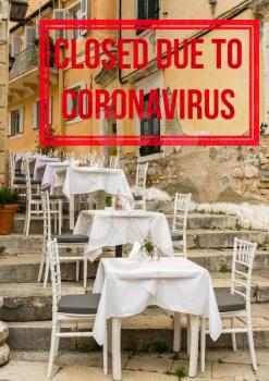 Empty tables and chairs of outdoor cafe in greek island of Corfu closed due to coronavirus