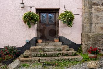 Solid wooden front door at the top of stone steps in the pretty Devon village of Dunsford