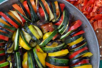 Ratatouille. Vegetable dish. Peasant food. Vegetables, cut into slices. Zucchini, pepper, tomato, eggplant. Kitchen. Recipes. Delicious. It is useful. Horizontal