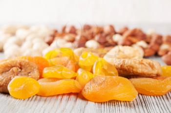 Dried fruits and nuts on a wooden background. Candied fruits, lemon, apricot, fig and nuts.