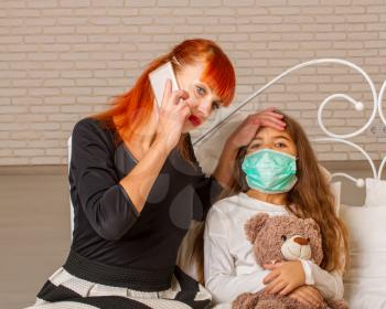 A little girl with her favorite teddy bear is sick in bed and her mother calls the doctor for counseling