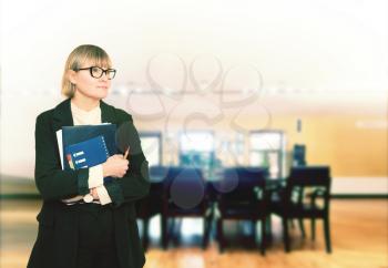 business woman in a formal suit and glasses is thinking in an empty office