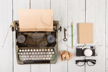 writer's workplace - wooden desk with vintage typewriter  and other supplies