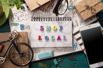 Shop local concept - inscription and office supplies on the desk 
