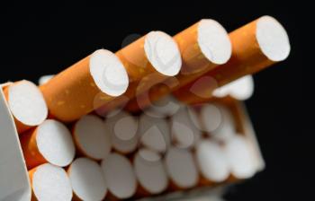 Closeup shot of white pack of cigarettes on a black background.