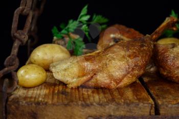 Roasted Goose Meat Served With Potatoes, Stuffing and Fresh Parsley On a Wooden Surface
