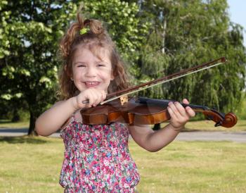 little girl with violin in park