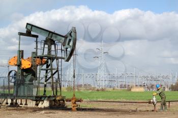 oil field with pumpjack and oil worker