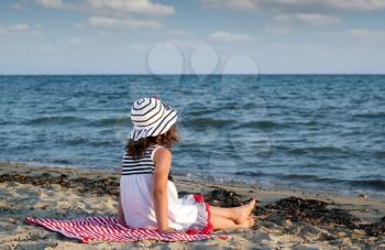 little girl sitting on beach