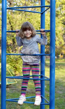 happy little girl climb on park playground