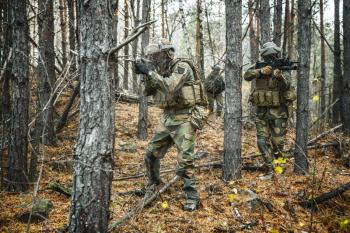 Norwegian Rapid reaction special forces FSK soldiers in field uniforms patrolling in the forest trees