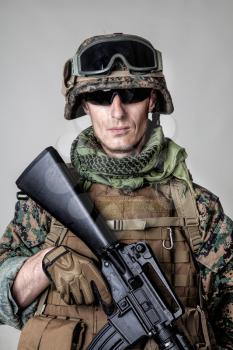 Studio shot of United States Marine with rifle weapons in uniforms. Military equipment, army helmet, combat boots, tactical gloves. Isolated on white, weapons, army, patriotism concept