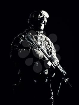 Special operations forces soldier, counter terrorism squad fighter, security service guard, marine shooter in combat uniform, armed with light machine gun low light studio shot on black background