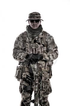 Army special forces soldier, commando shooter, mercenary in camouflage uniform, bonnie, hidden behind mask and glasses face, armed service rifle, carrying backpack on back, isolated studio shoot