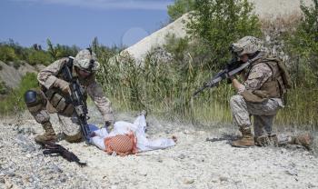 Two US marines making a search of killed muslim warrior