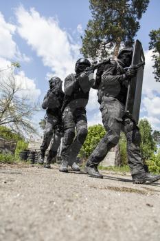 Spec ops police officers SWAT in black uniform in action