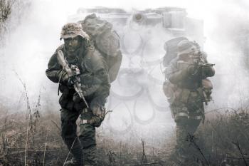 Jagdkommando soldiers Austrian special forces and tank moving on terrain in the fog. They are ready to face the enemy. NATO military power concept