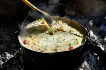 Boiling soup in a pot above the fire.