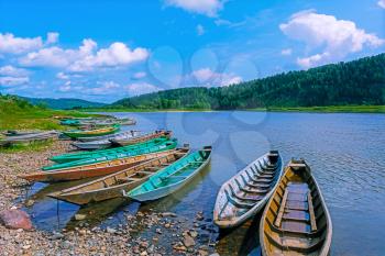 Wooden boats moored to the bank of the river. Beautiful river landscape.