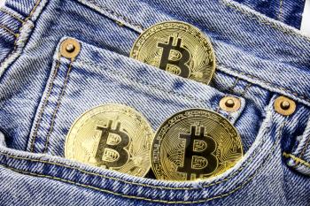 Three golden bitcoin coins on the pockets of the jeans. Concept of making money with online business. Making money motivational message. Online making money with bitcoin.