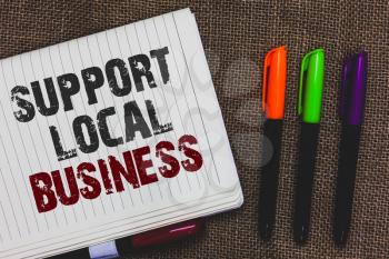 Text sign showing Support Local Business. Conceptual photo increase investment in your country or town Open notebook page jute background colorful markers Expressing ideas