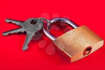 Padlock and keys against a red background