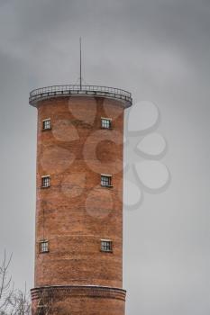 Vintage style red brick water tower of an old factory.