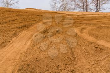 Trail of treads on a sandy quarry background.