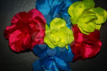 Hand made flowers created from colorful satin ribbons close up.