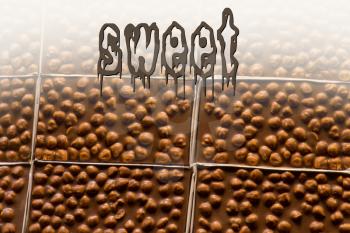 SWEET written over home made chocolate bars as background